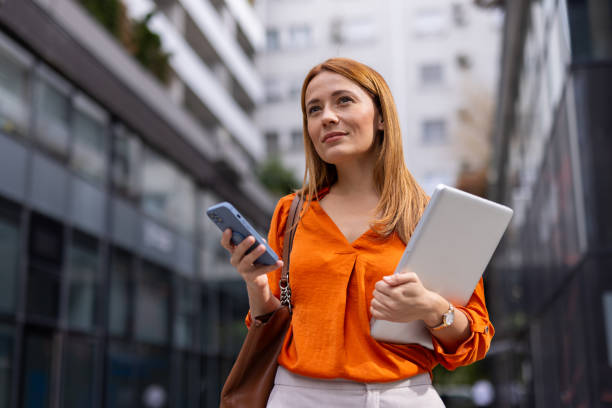 Businesswoman holding her phone confidently Businesswoman holding her phone confidently
