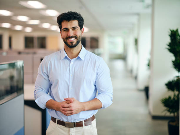 A man standing in a company office. A man standing in a company office.