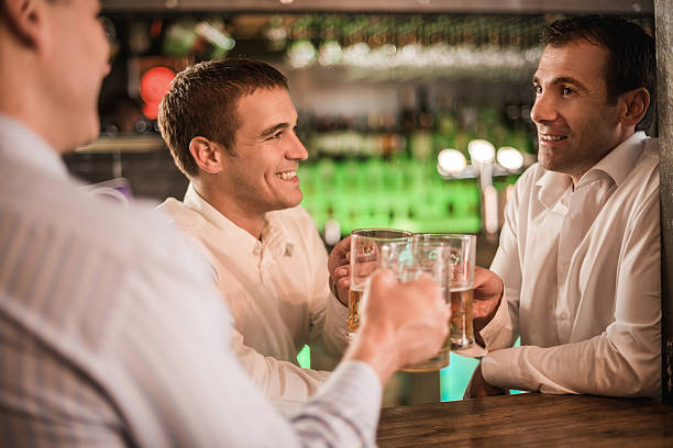 Three happy businessmen enjoying in a bar after work and toasting with beer. Three happy businessmen enjoying in a bar after work and toasting with beer.